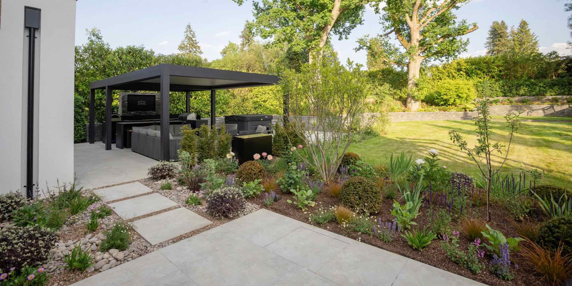 Contemporary Hertfordshire Garden with pale grey porcelain paving, steel pergola, sociable outdoor lounge and dining areas and steel pergola with hot tub