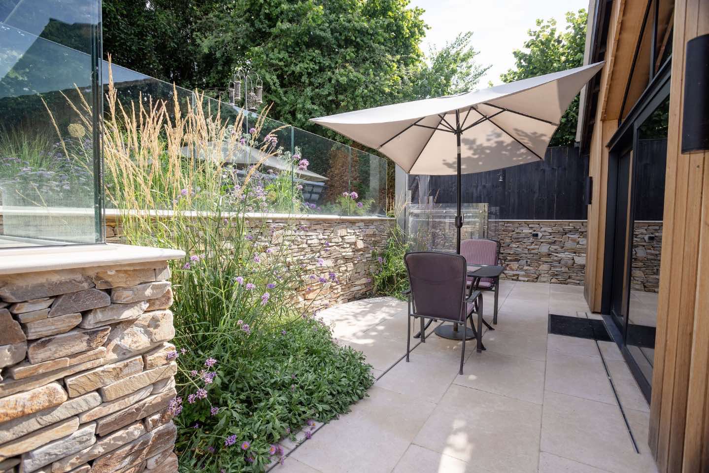 Walled garden using yellow quartz paddlestones with airy naturalistic planting