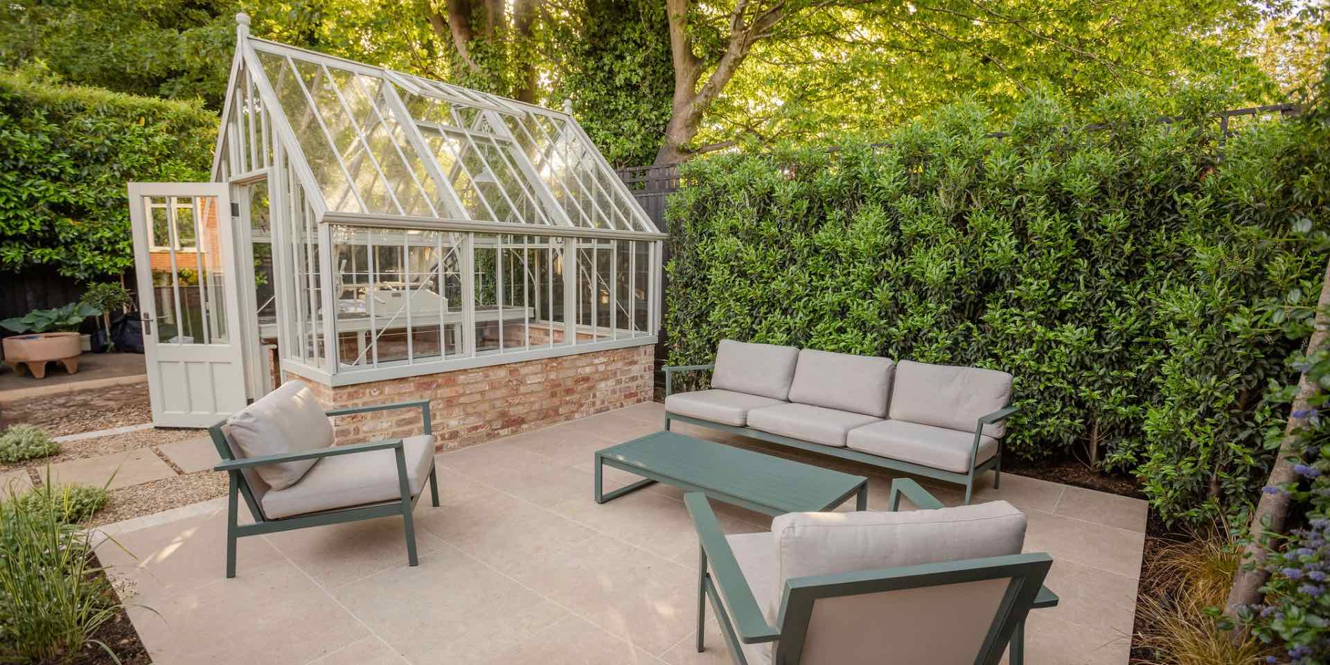 Alitex Hidcote greenhouse with limestone paving and Heals EOS outdoor lounge furniture