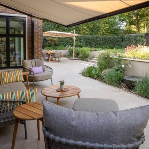 Luxury Family Garden in Harpenden with limestone paving, lounge seating and Foras water feature