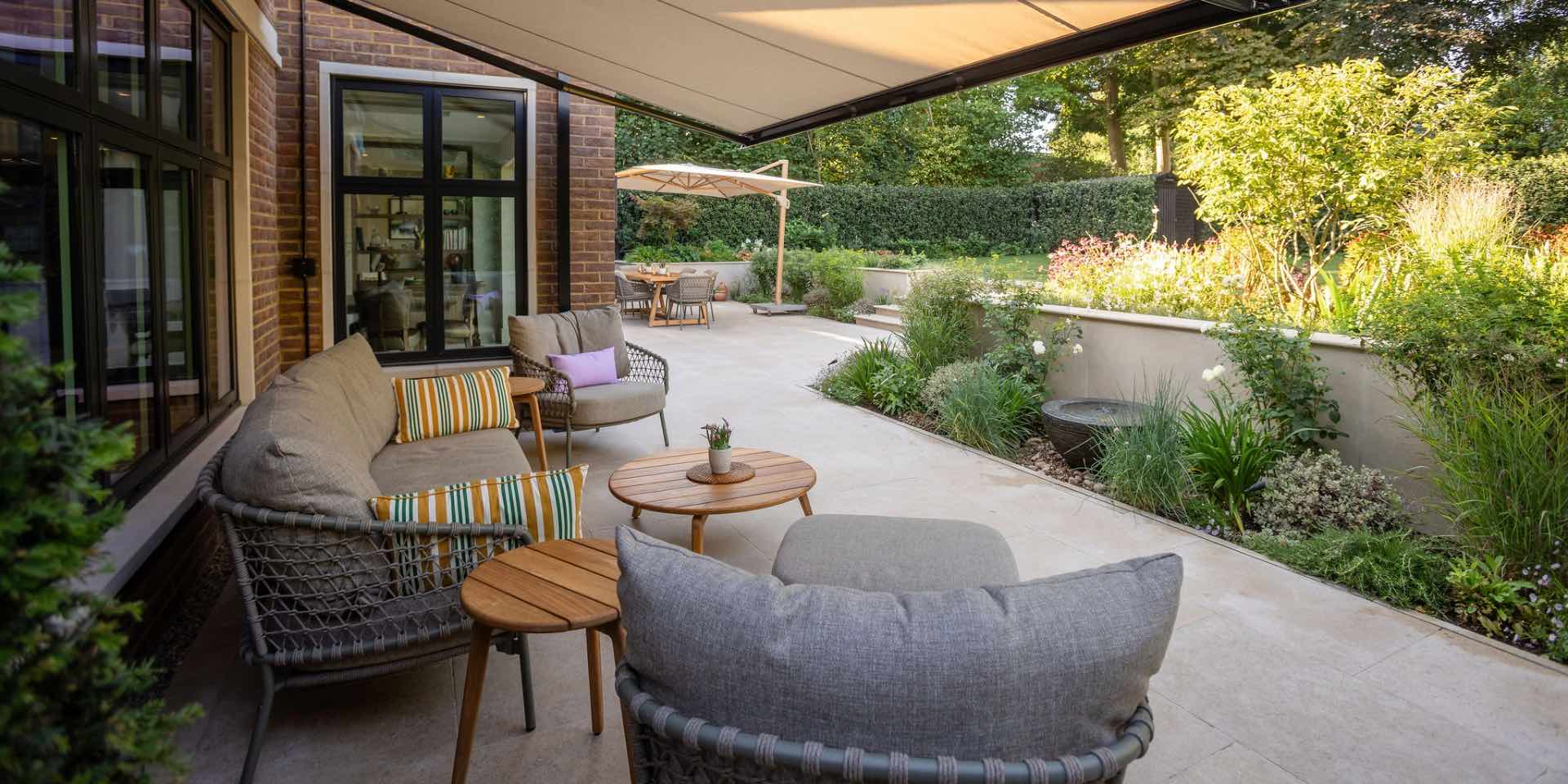 Luxury Family Garden in Harpenden with limestone paving, lounge seating and Foras water feature