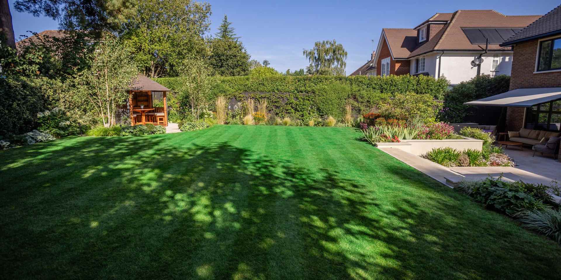 Large lawn with Breeze House, rich colourful planted borders for full sun and limestone steps into a sunken garden in Harpenden, Hertfordshire