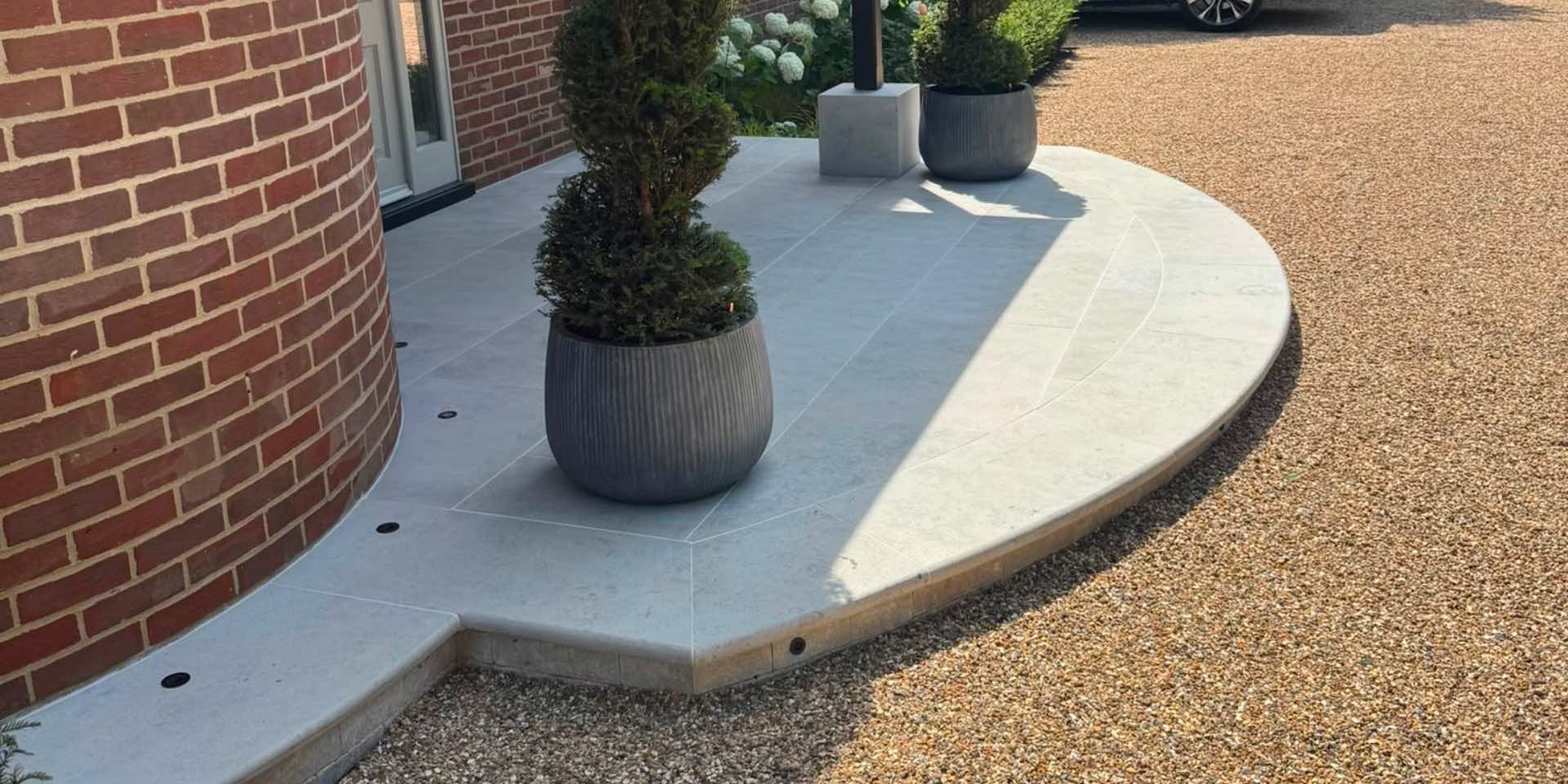 Jura Grey Limestone Paving curved entrance platform to front door with two circular planters with Yew spirals