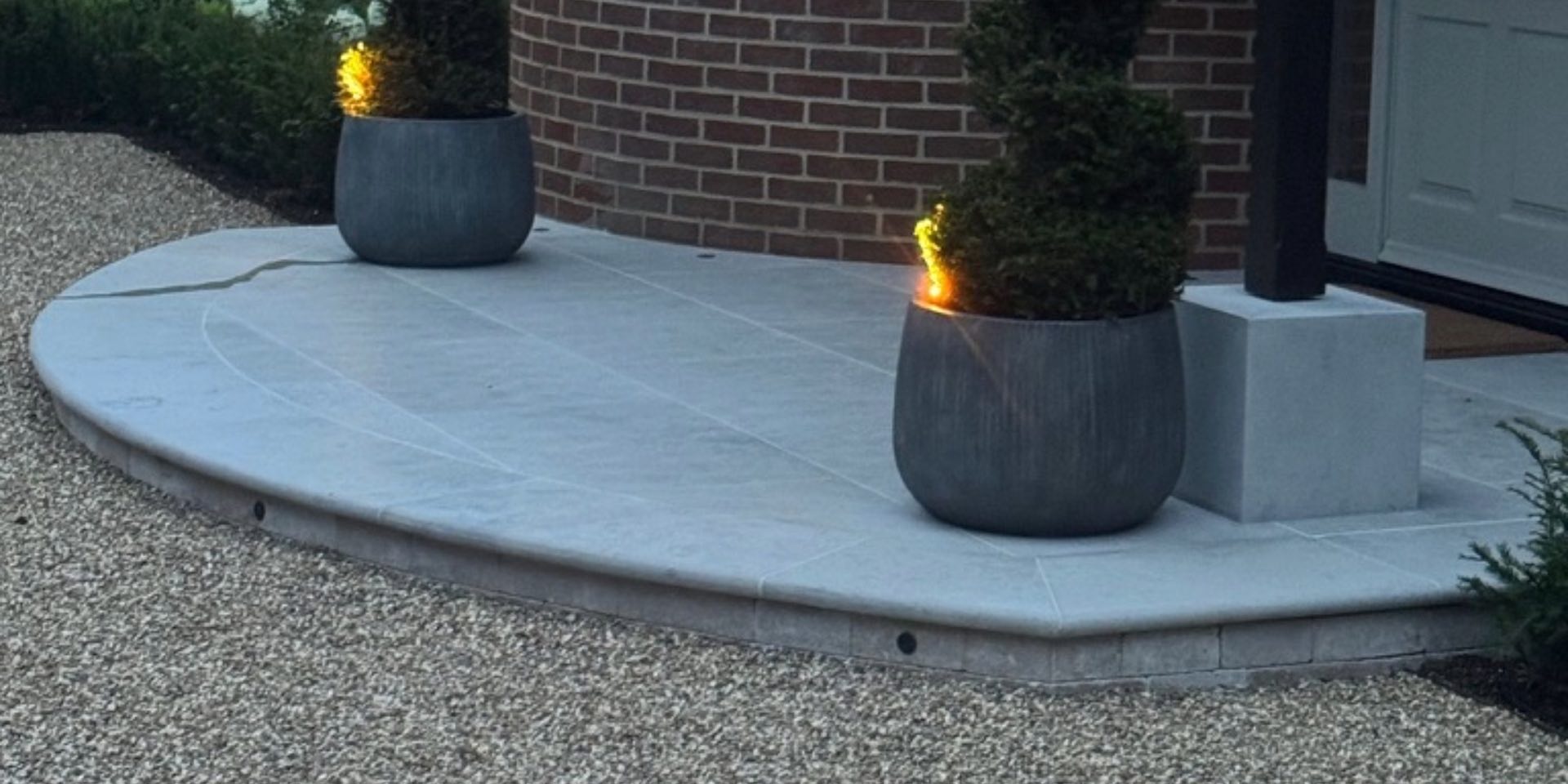 Limestone grey entrance platform with circular dark grey planters