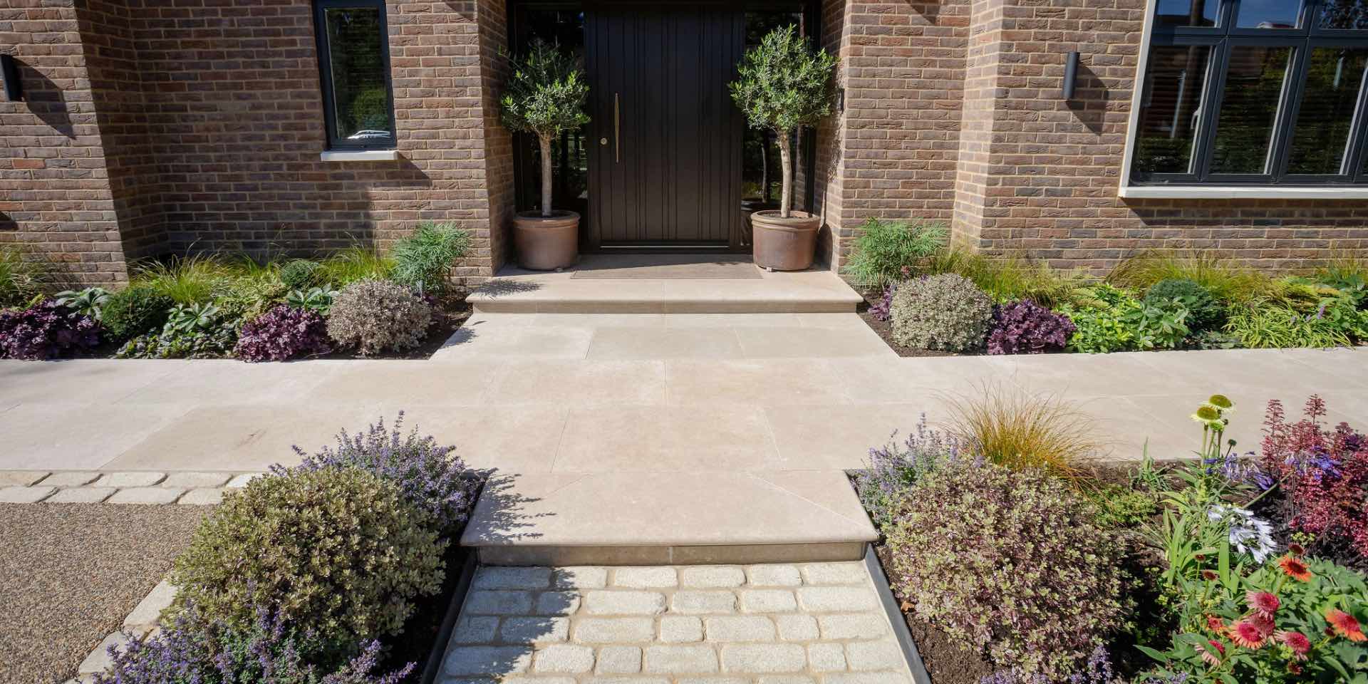 Limestone paving path and granite setts path with Pittosporum balls and other colourful evergreen planting