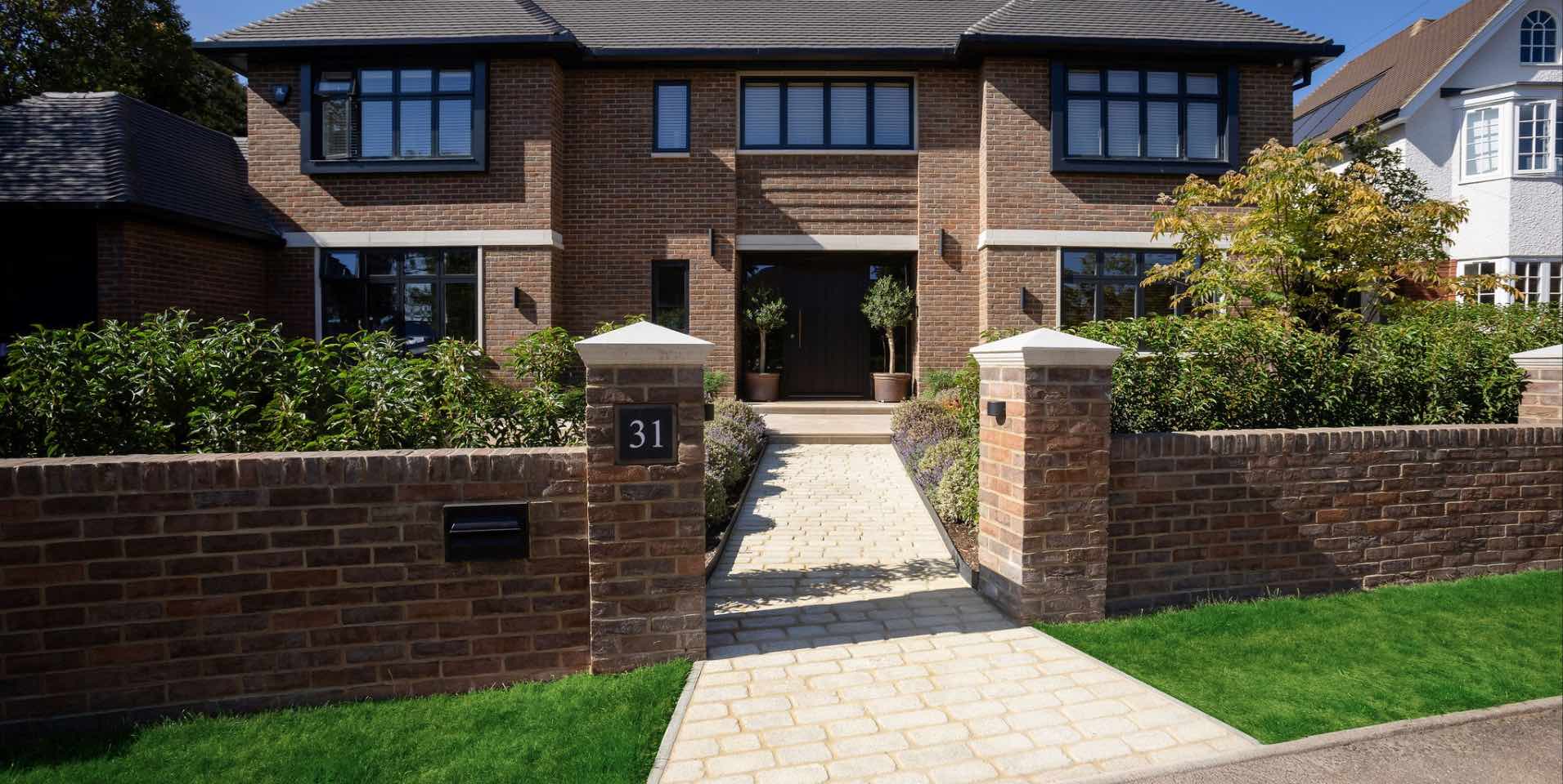 Re-designed front garden in Harpenden with granite sett path and new brick boundary wall with pier caps