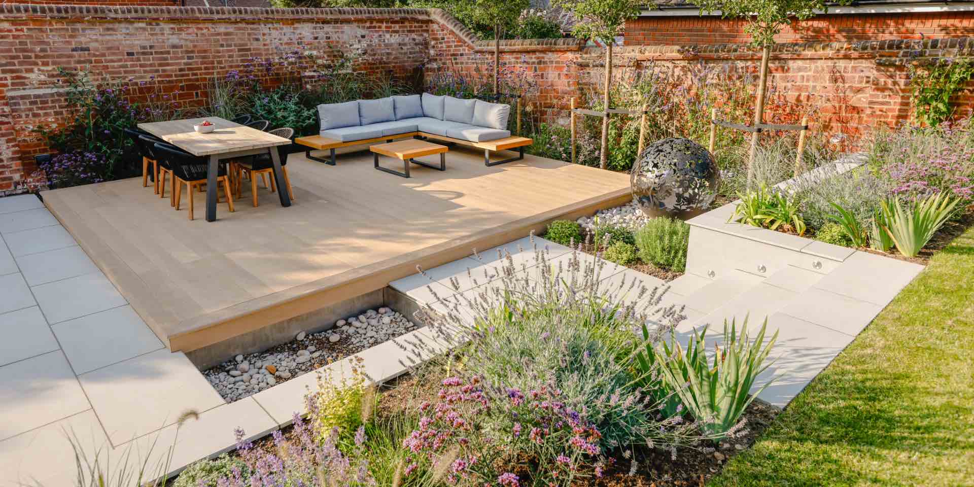 Hitchin garden with decking, dining table and outdoor sofa