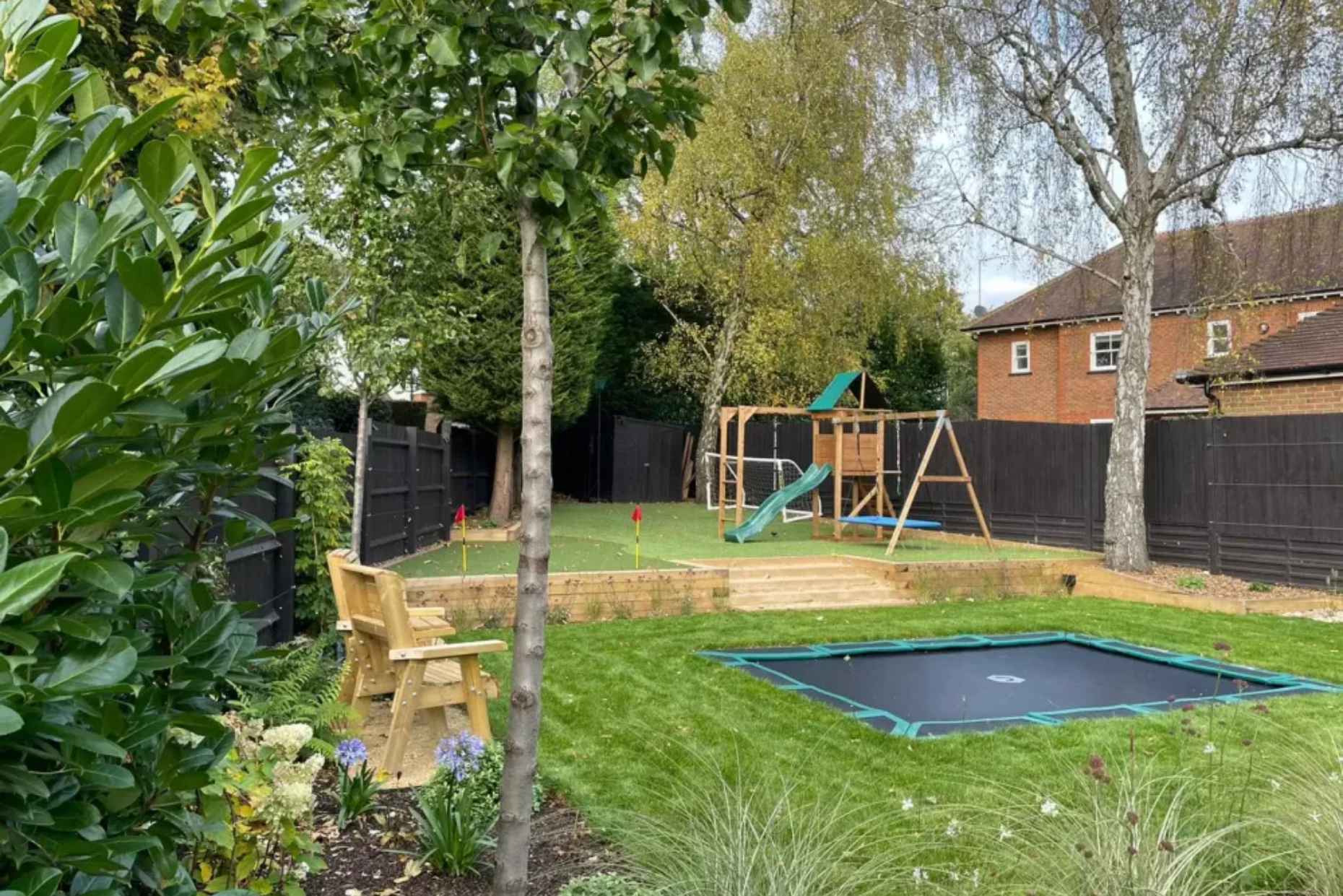 Family garden in Harpenden with in ground trampoline and astro turf play.